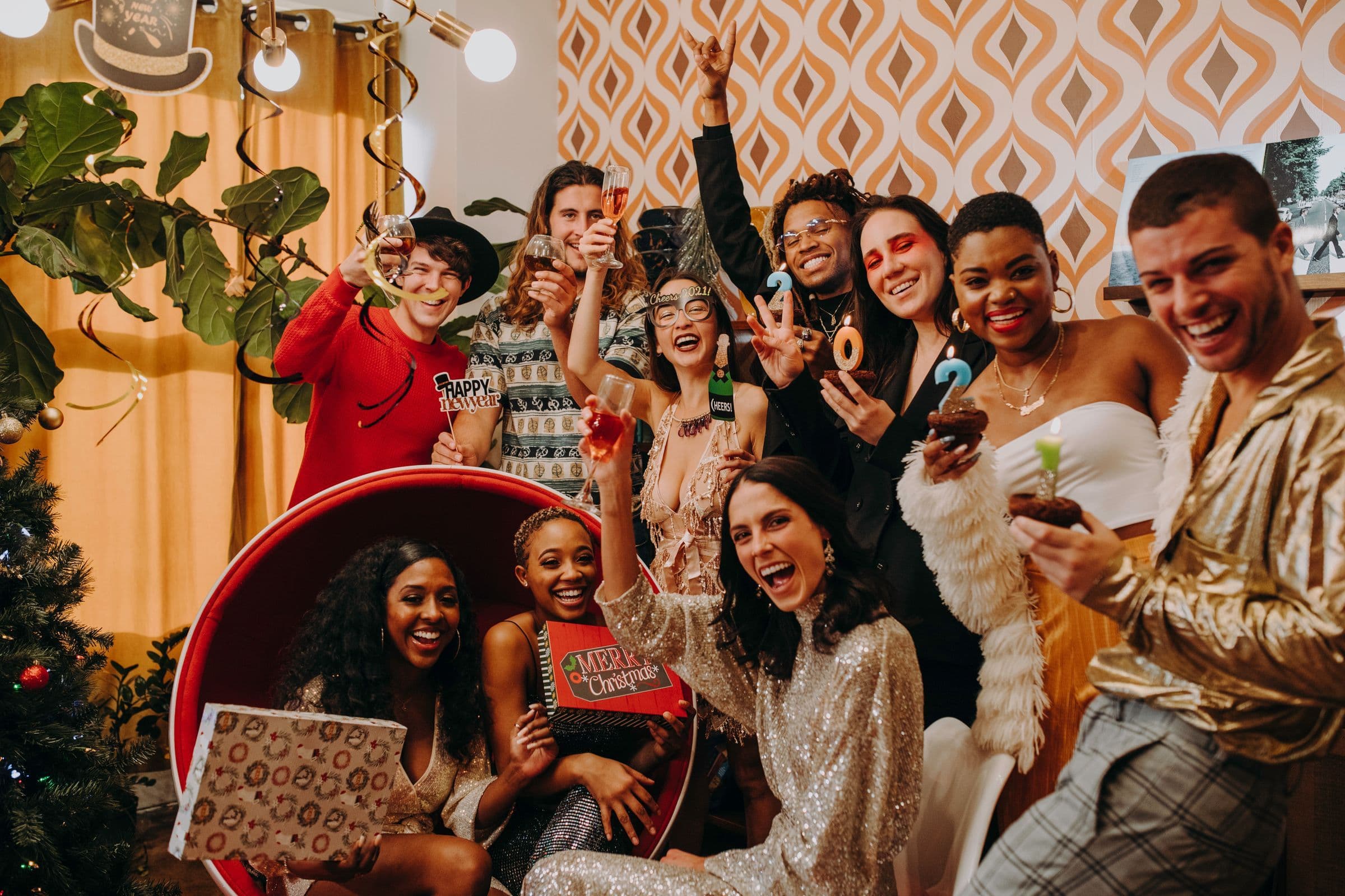 A diverse group of friends cheering and raising glasses at a festive New Year's Eve party