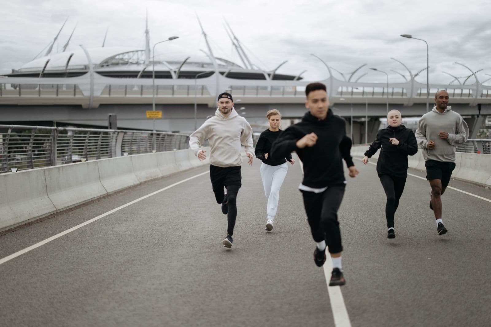 Group of adults jogging together on an urban road